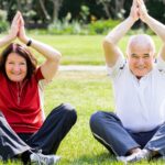 Couple Practising Yoga In Park