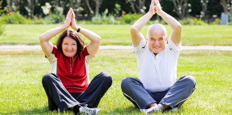 Couple Practising Yoga In Park